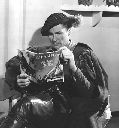 Flynn - taking a break from shooting THE PRINCE & THE PAUPER - checks a review copy of his first novel, BEAM ENDS (30kb)